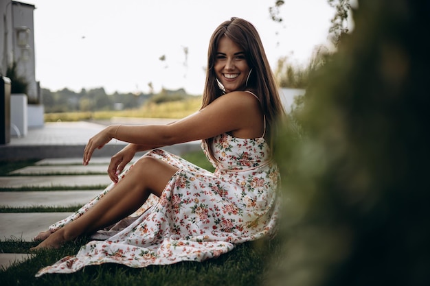 Mulher atraente em vestido de verão, sentado no chão