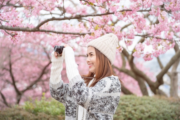 Mulher atraente está desfrutando com flor de cerejeira em Matsuda, Japão