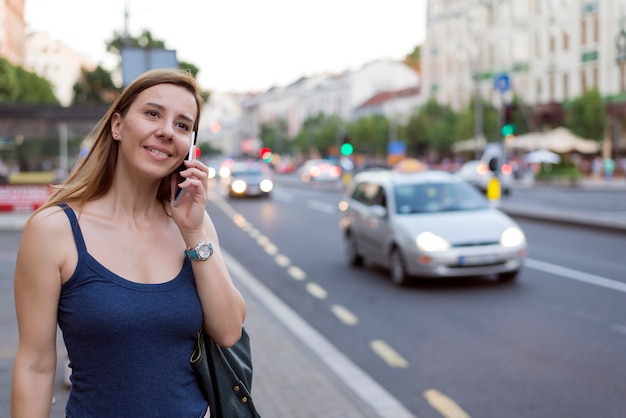 Mulher atraente, falando ao telefone na rua