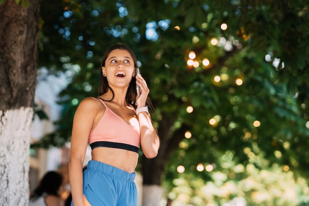 Mulher atraente falando no celular em uma rua de verão