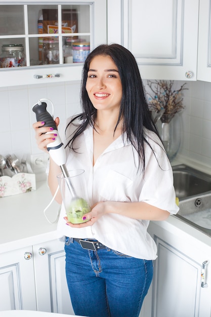 Mulher atraente fazendo smoothie dentro de casa