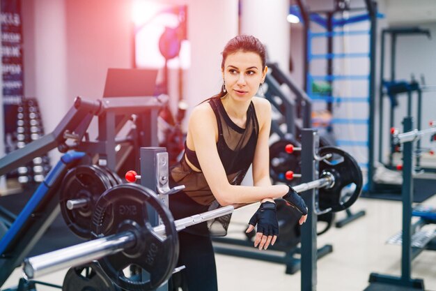 Mulher atraente na academia Jovem esportiva descansando depois do treino