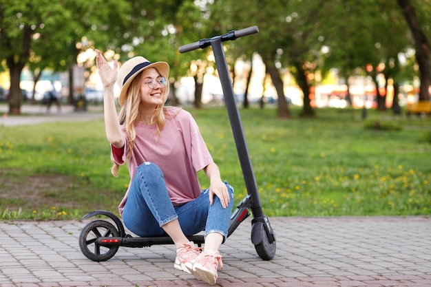 Mulher atraente no verão com scooter eletrônica para um passeio de boas-vindas