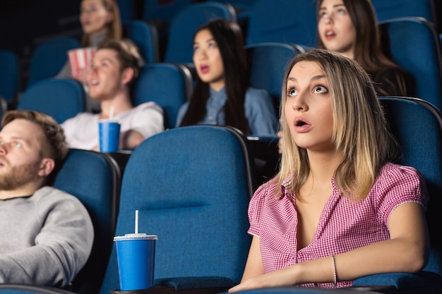 mulher atraente olhando chocado assistindo a um filme no cinema