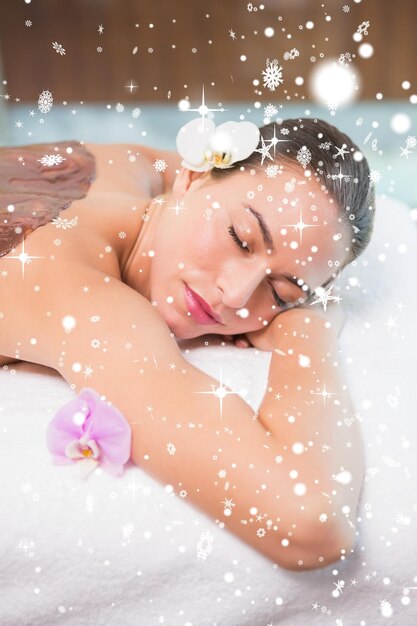 Mulher atraente recebendo máscara de chocolate no centro de spa contra queda de neve