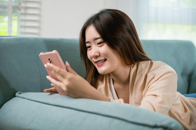 Mulher atraente sorridente relaxada lendo mensagem de texto no smartphone
