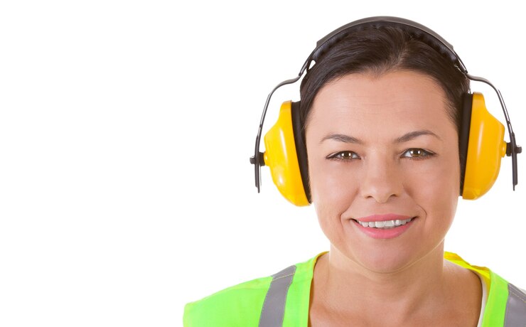 Foto mulher atraente trabalhador com jaqueta de segurança e fones de ouvido protetores com copyspace para seu projeto em um fundo branco