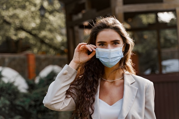 Foto mulher atraente usando máscara médica ao ar livre no parque