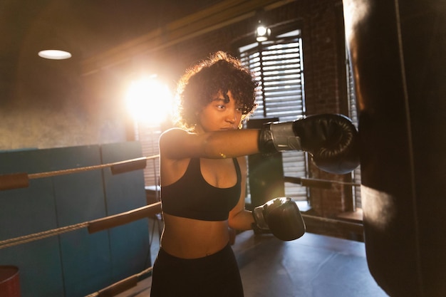 Mulher autodefesa girl power afro-americana lutadora treinando socos no ringue de boxe saudável