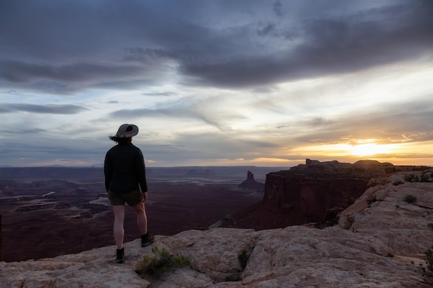 Mulher aventureira caminhando em um canyon deserto com montanhas de rocha vermelha