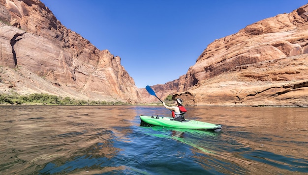 Mulher aventureira em um caiaque remando no rio colorado glen canyon arizona