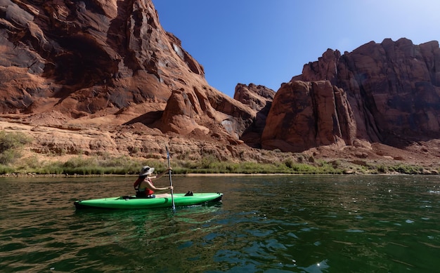 Mulher aventureira em um caiaque remando no rio colorado glen canyon arizona