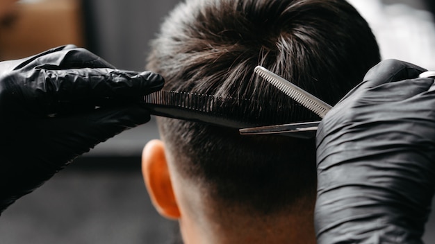 Mulher barbeiro cortar cabelo para um homem barbudo.