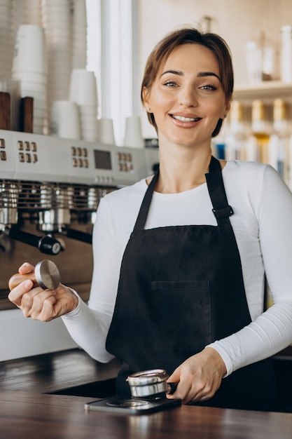 Mulher barista em uma cafeteria preparando café