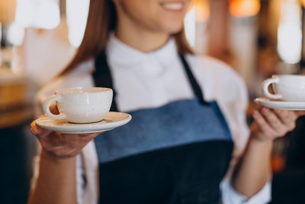 Mulher barista na cafeteria segurando café expresso