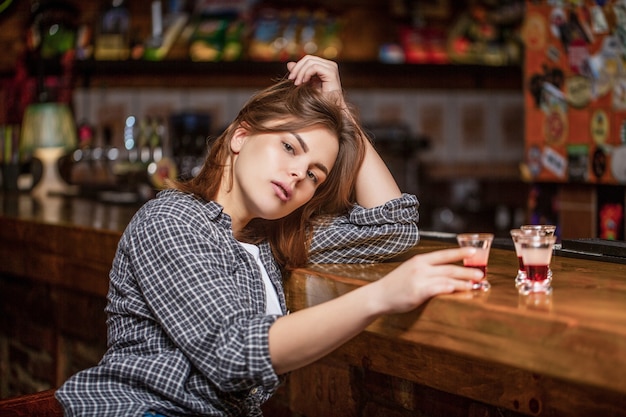 Mulher bêbada segurando um copo de uísque ou rum. Mulher em depressão