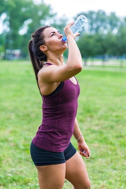 Mulher bebendo água após esporte