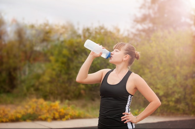 Mulher bebendo água durante esportes