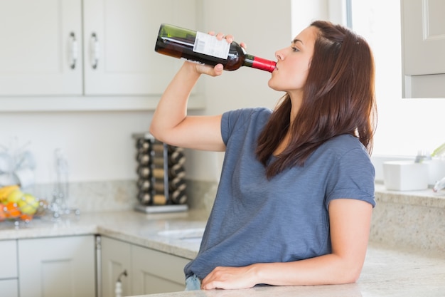 Mulher bebendo apenas uma garrafa de vinho