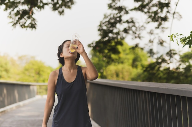 Foto mulher bebendo bebida energética depois de correr no parque