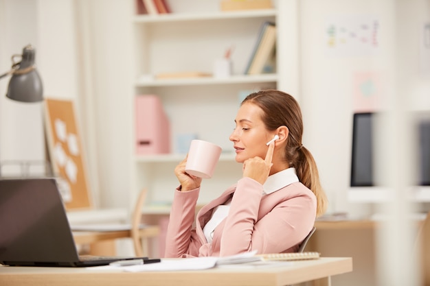 Mulher bebendo café e talknig no telefone