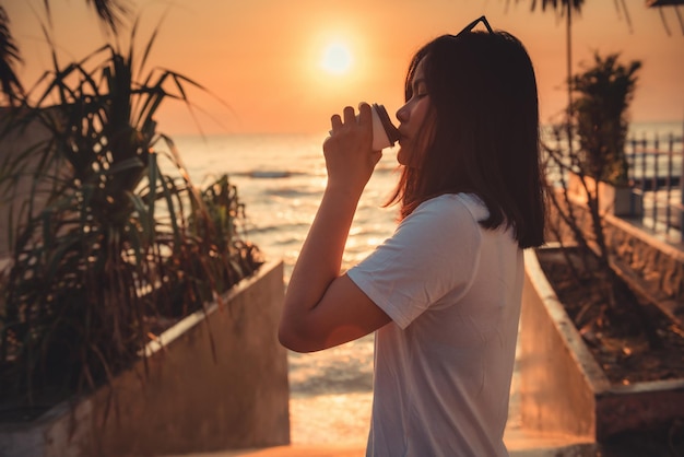 Foto mulher bebendo café na praia