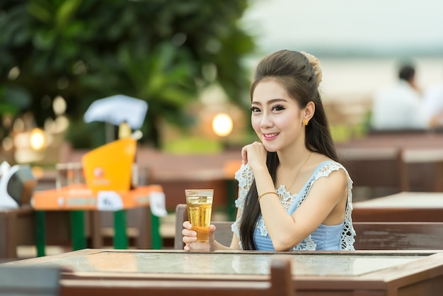 Mulher bebendo cerveja no café. bela jovem asiática