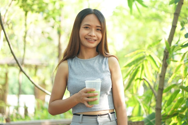 Mulher bebendo chá verde gelado no café café