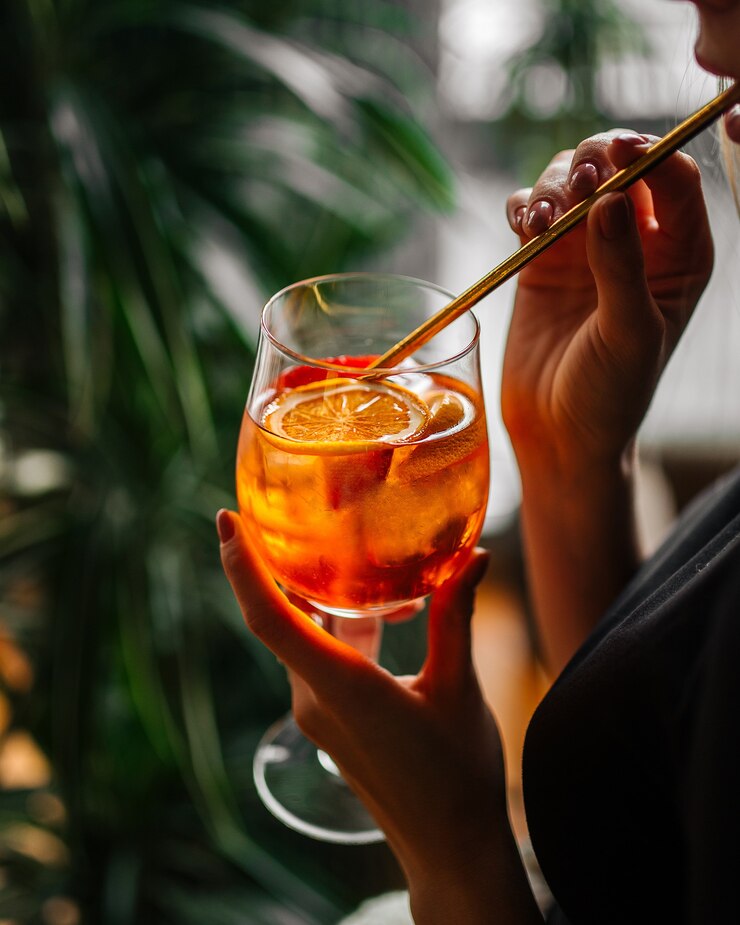 Foto mulher bebendo coquetel de aperol com canudo de vidro