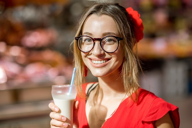 Mulher bebendo horchata, bebida tradicional espanhola feita com amêndoas, em pé no mercado de alimentos central da cidade de valência