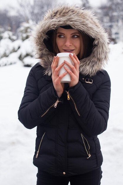 Mulher bebendo seu chá de bebida quente ou café da xícara. Inverno.