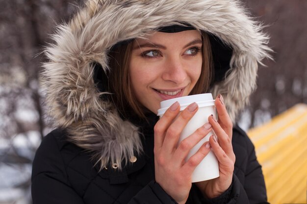 Mulher bebendo seu chá ou café de bebida quente da xícara Temporada de inverno