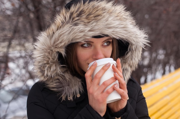 Mulher bebendo seu chá ou café de bebida quente da xícara Temporada de inverno