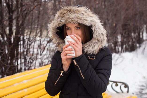 Mulher bebendo sua bebida quente do copo Temporada de inverno