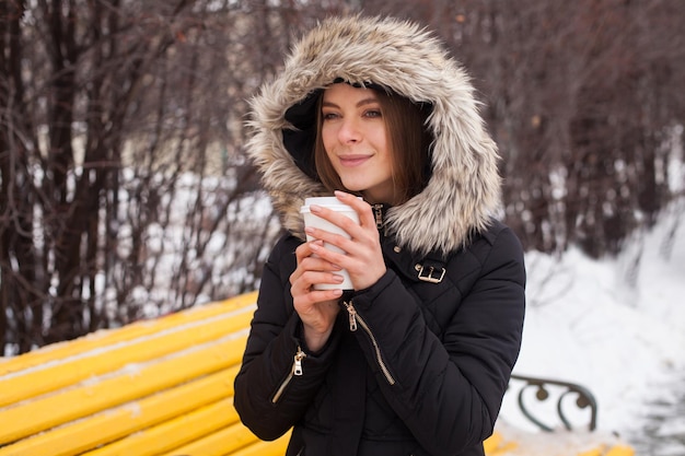 Mulher bebendo sua bebida quente do copo Temporada de inverno