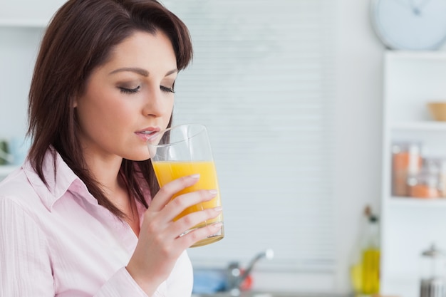 Foto mulher bebendo suco de laranja