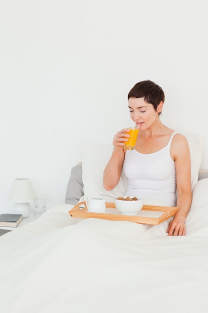 Mulher bebendo suco para o café da manhã