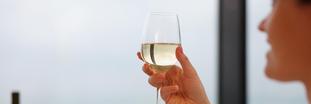 Mulher bebendo vinho branco de vidro fechado