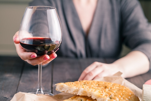 Mulher bebendo vinho e comendo pão