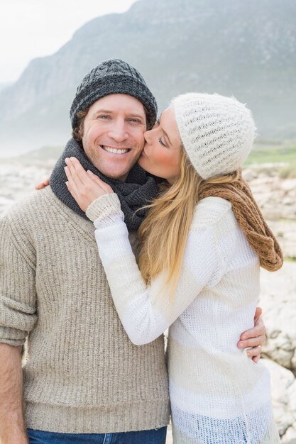 Mulher beijando um homem em paisagem rochosa