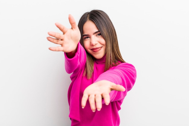 Mulher bem hispânica sorrindo alegremente dando um caloroso abraço de boas-vindas, sentindo-se feliz e adorável