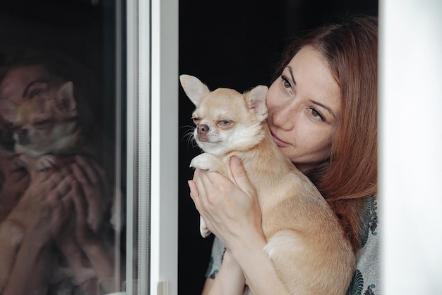 Mulher bem madura com cachorro chihuahua nas mãos