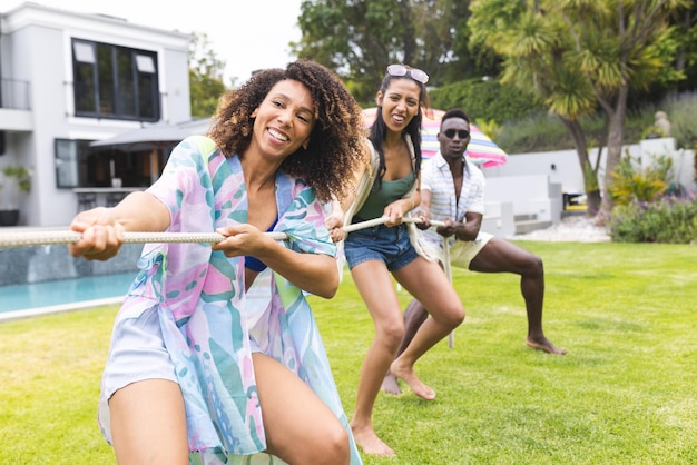 Mulher biracial e jovem afro-americano se envolvem em um brinquedoso puxão de guerra