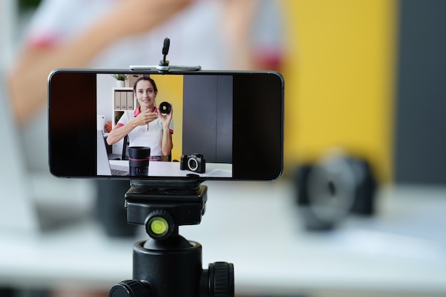 Mulher blogueira faz análise de equipamentos fotográficos e lentes para fotos de alta qualidade