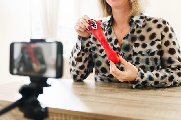 Mulher blogueira fazendo vlog com uma resenha de brinquedo sexual