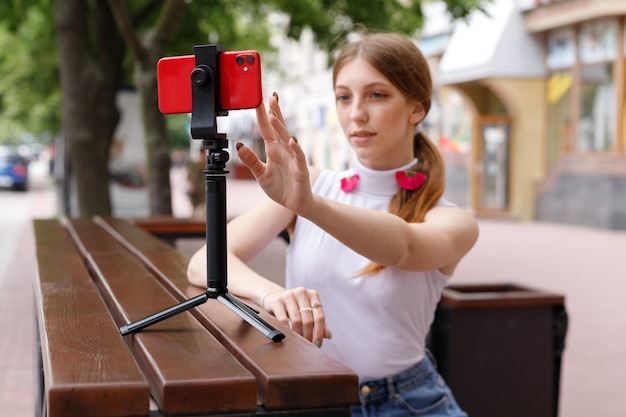 Mulher blogueira tira selfie em smartphone vermelho