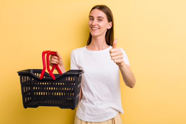 Mulher bonita adulta jovem segurando uma cesta de compras vazia