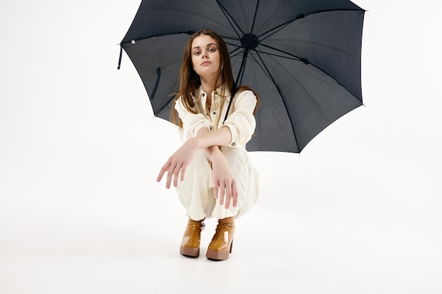 Mulher bonita agachada com guarda-chuva aberta estilo moderno foto de alta qualidade