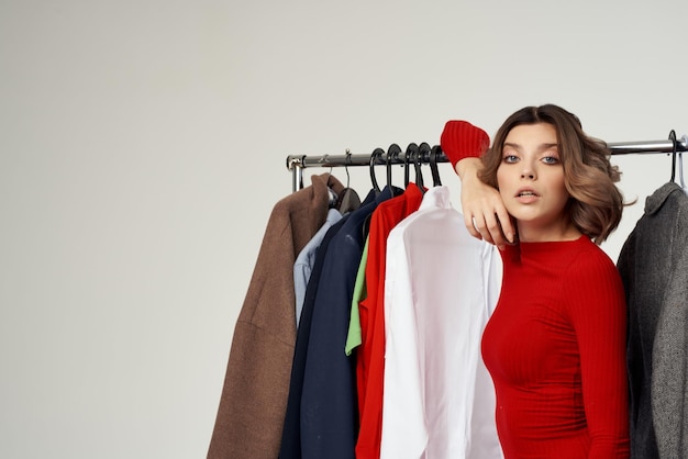 Foto mulher bonita ao lado de roupas moda divertido varejo fundo isolado foto de alta qualidade