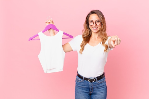 Mulher bonita apontando para a câmera, escolhendo você e escolhendo as roupas